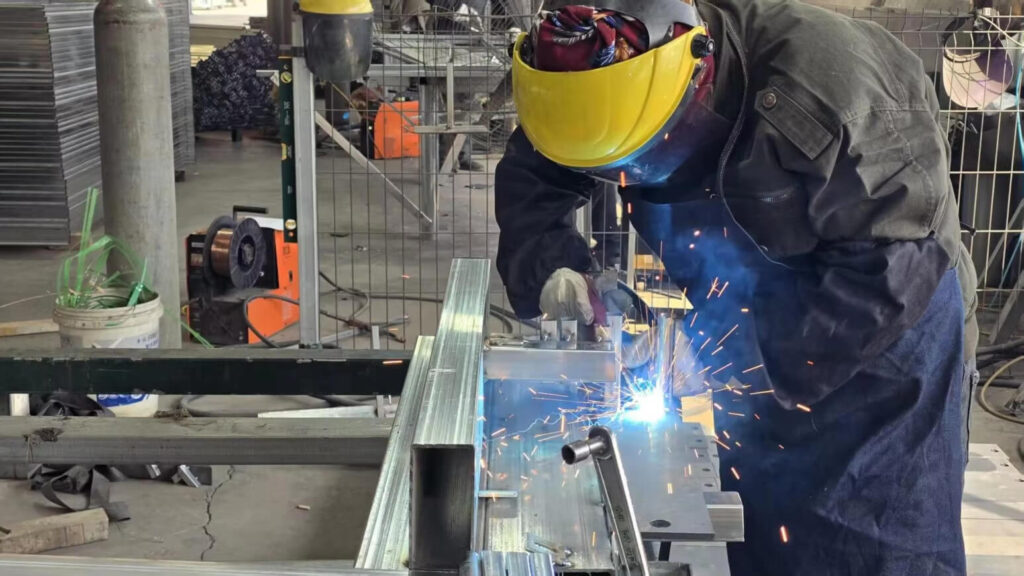 Workers welding during iron door production